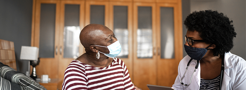A woman patient wearing mask facing her doctor A woman patient wearing mask facing her doctor