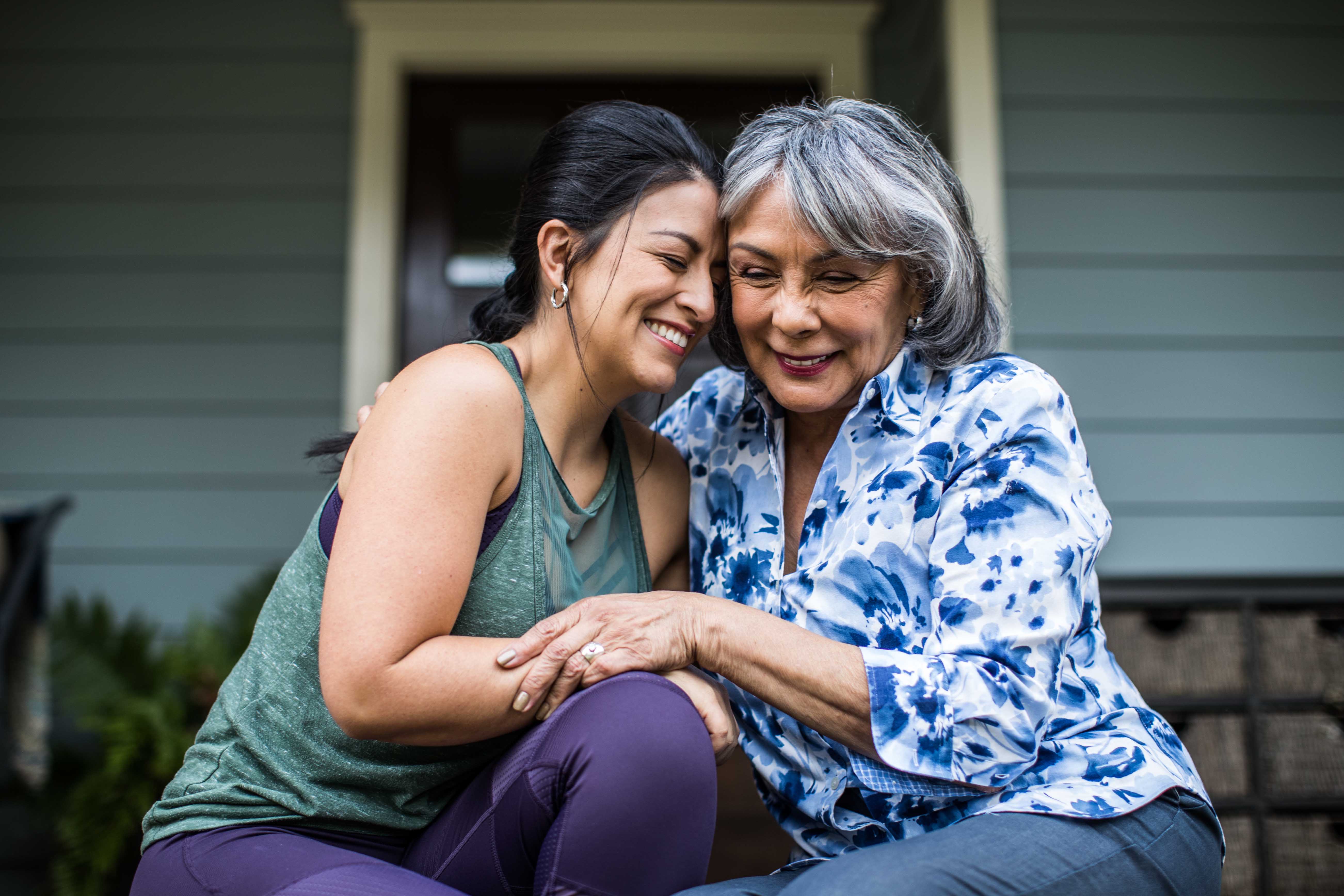 Mother and daughter smiling as they embrace