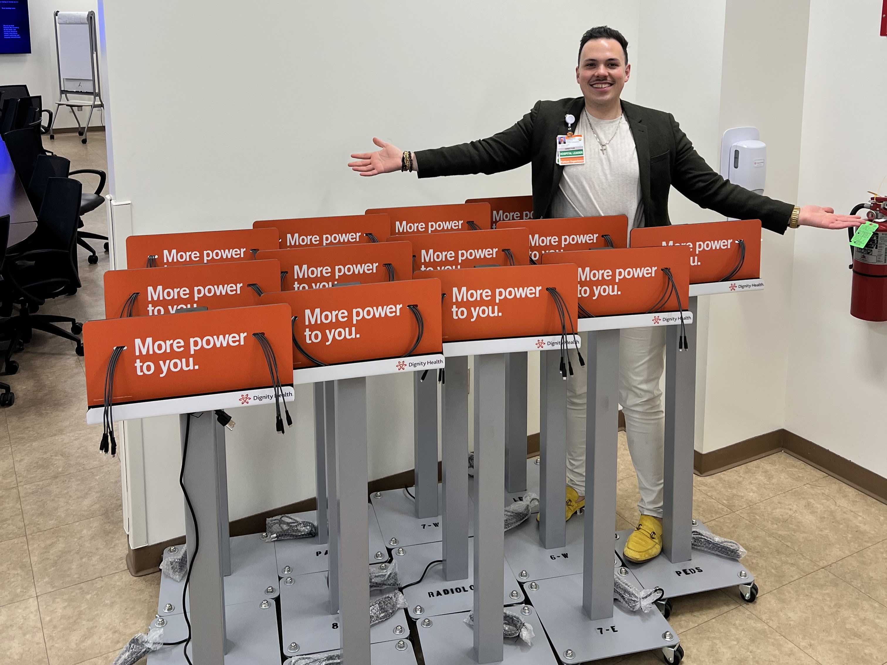 Garrett South, Director of Patient Experience at CHMC, standing with the Mobile Phone Charging Carts