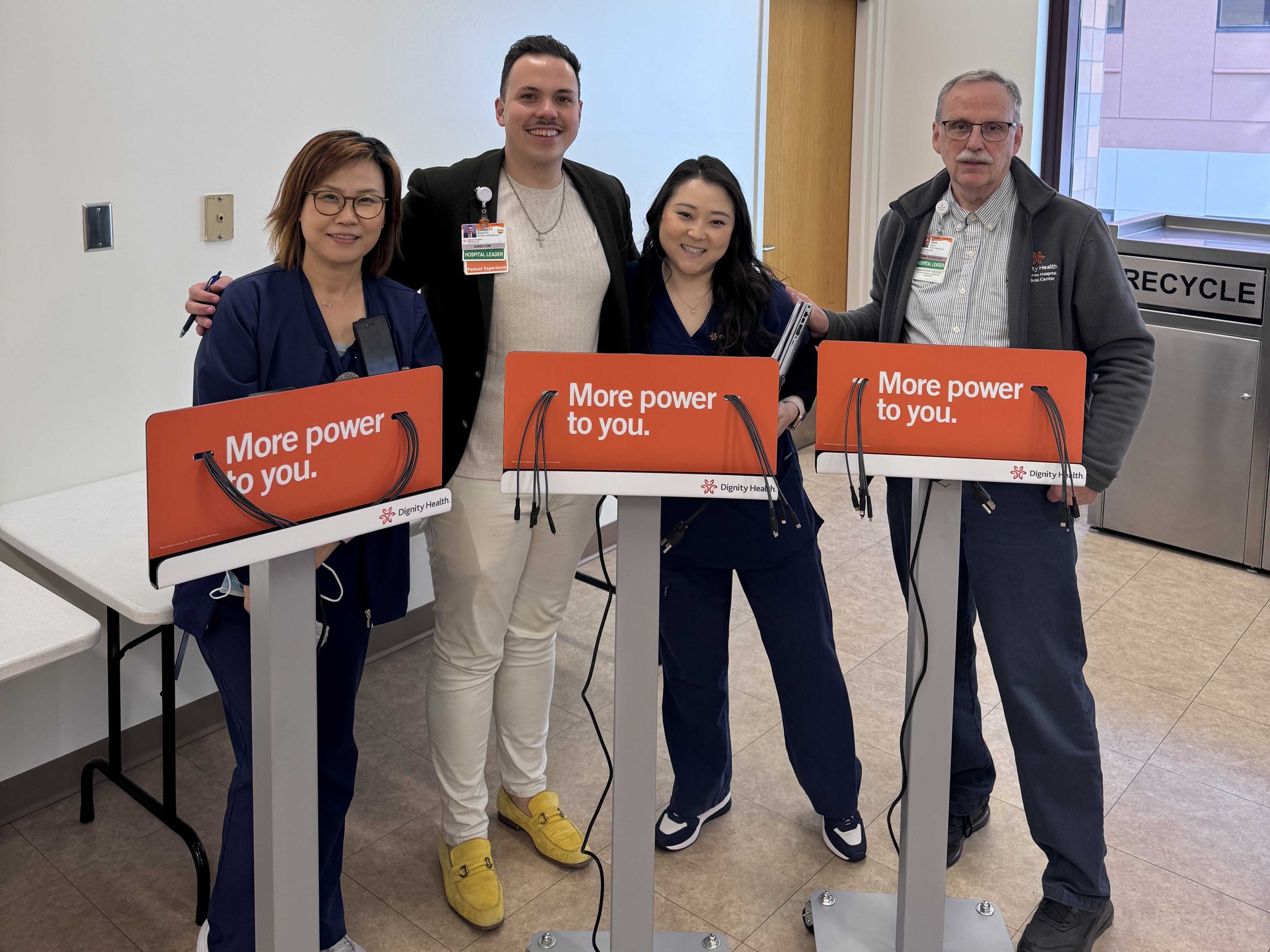 CHMC staff standing with Mobile Phone Charging Carts 