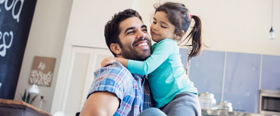 Smiling father holding his smiling daughter