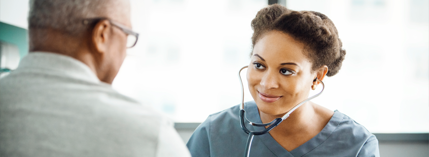 Nurse with stethoscope smiling at patient